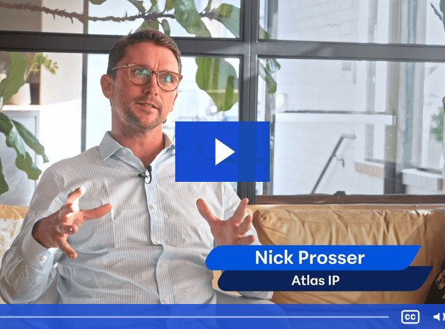 A person wearing glasses and a light blue shirt sits on a couch, gesturing with hands. The background shows plants and a window. Text overlay reads "Nick Prosser, Atlas IP, Telarus Capital." Video controls are visible at the bottom.